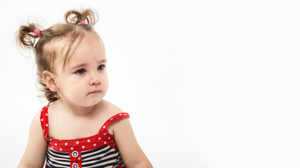 Studio portrait of cute, adorable, sad, upset, crying caucasian toddler girl in dress on isolated white background