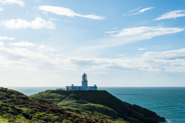Fototapeta na wymiar The lighthouse at Strumble Head, surrounded by the wild coastline and sea of Pembrokeshire. Wales.