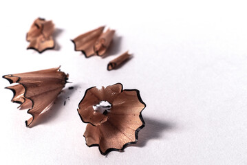 Macro detail closeup of wooden curly pencil shavings on white paper background - Concept of studying, school homework, planning, drawing or writing