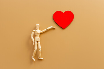 Love emotion concept. Wooden mannequin figure with heart