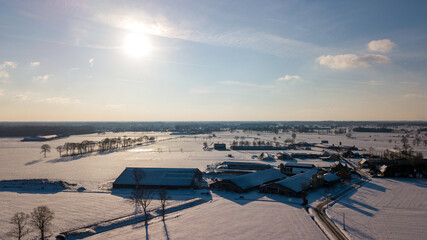 Fototapeta premium Aerial view with a drone of a spring wavy agricultural countryside landscape with plowed and unplowed fields and trees in the blue evening sky. High quality photo