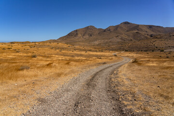 Panoramic view of of mountains with a dirt road in the Gata Cape Natural Park coast. Almería, Andalucía, Spain.