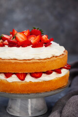 Victoria`s sponge cake, delicious homemade vanilla cake decorated with whipped cream and fresh strawberries