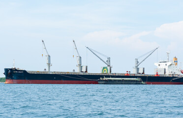 Fototapeta premium Crane in the industrial ship in the ocean blue water and blue sky landscape,Logistic and transportation ship concept in the sea