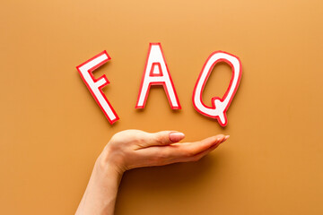 Hands with faq - frequently asked questions - paper letters, top view