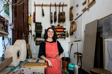 woman luthier making guitars in her musical instrument workshop