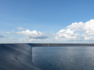Reservoir on the mountain landscape with wind turbine and cloudy on blue sky,Water in reservoir