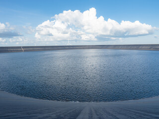 Water in reservoir on the mountain landscape with wind turbine and cloudy on blue sky,Dam in Thailand