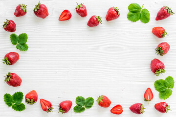 Flat lay of ripe strawberries with green leaves