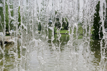 inside view of the falling water of the waterfall against the nature landscape background. water in...