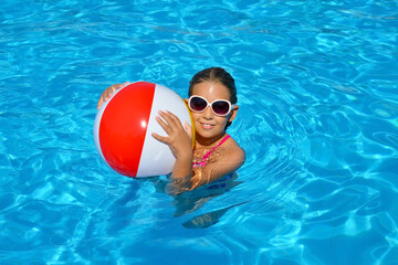 Real adorable girl relaxing in swimming pool