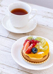 白いお皿の上のフルーツタルトとコーヒーカップ