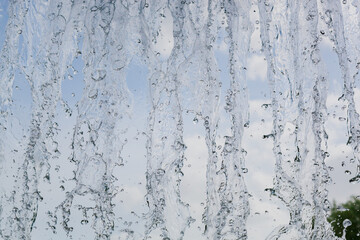 inside view of the falling water of the waterfall against the blue sky. water in motion