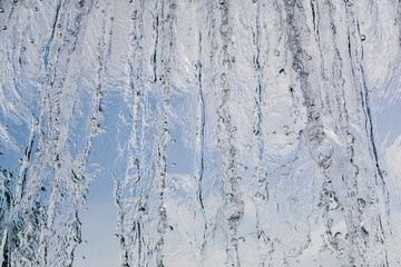 inside view of the falling water of the waterfall against the blue sky. water in motion