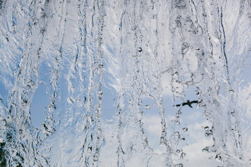 inside view of the falling water of the waterfall against the blue sky. water in motion