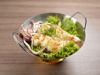steamed octopus with spicy chilli sauce in hot pot on wood table asian halal menu