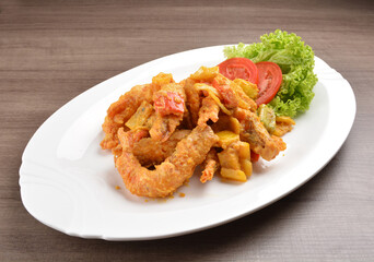 wok fried tiger prawn in salted egg yolk curry paste sauce on wood table asian halal menu