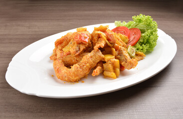 wok fried tiger prawn in salted egg yolk curry paste sauce on wood table asian halal menu