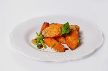 Caramesized carrots on a white plate and white background