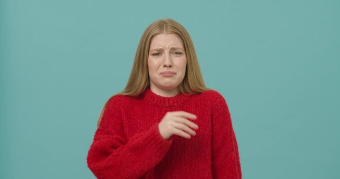 Pretty young woman with long blond hair is expressing emotion of disgust because of bad stench