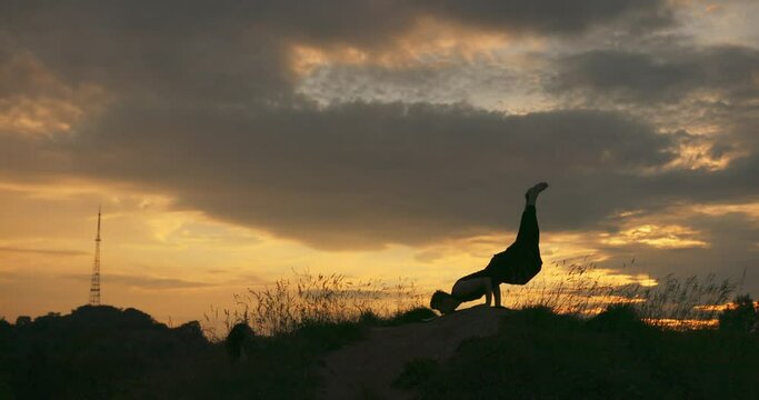 Silhouette of a man engaged in meditation at sunset sunlight. Man prays at sunset healthy way of lifestyle life nature.