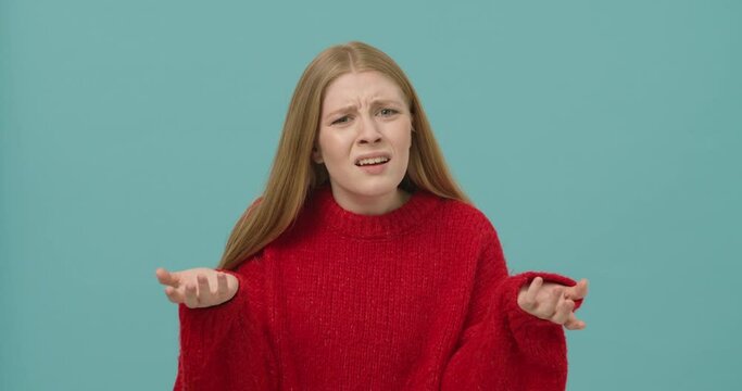 Young woman with long blond hair shrugging shoulders being upset and disappointed
