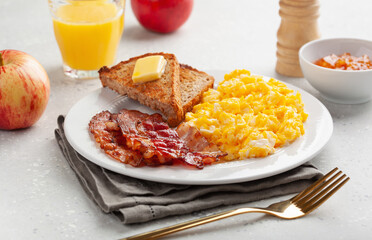 traditional scrambled egg breakfast with bacon and toast