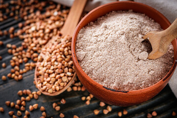 fresh natural buckwheat flour on a dark wooden rustic background culinary concept