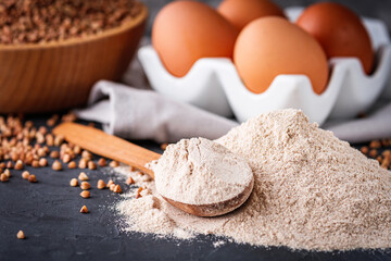 fresh natural buckwheat flour on a dark stone background culinary concept