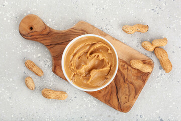 smooth peanut butter in bowl on gray background