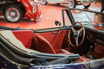 Closeup of a vintage car's salon made of red leather. A classic car interior.