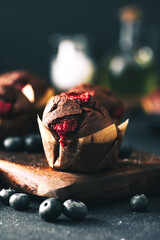 Muffin. Chocolate muffins with stawberry. Muffins on wooden stand.