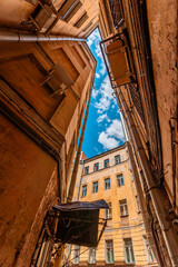 Fototapeta na wymiar View of the sky in the courtyard of houses in St. Petersburg