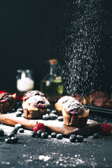 Muffin. Chocolate muffins with stawberry. Muffins on wooden stand with powder sugar. - obrazy, fototapety, plakaty