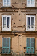 facade of typical italian buildng with balcony with shutters