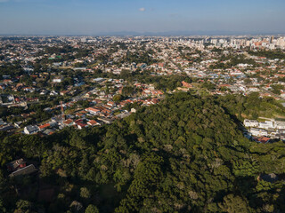 vista aérea da cidade de Curitiba com áreas de preservação em primeiro plano ao final da tarde. Paraná Brasil. 