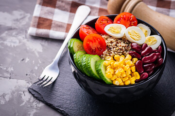 bowl of healthy quinoa with vegetables on a dark rustic background