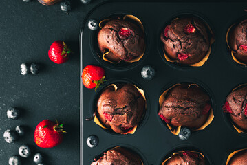 Muffin. Chocolate muffins with stawberry. Muffins on wooden stand. © Exploder