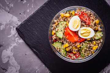 bowl of healthy quinoa with vegetables on a dark rustic background