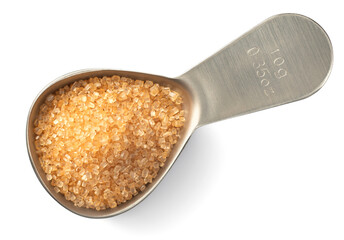 yellow sugar in the metal measuring spoon, isolated on white background, top view