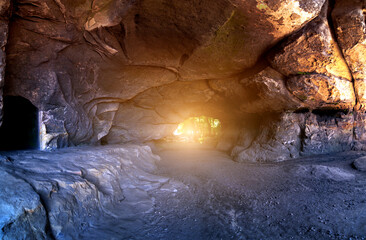 View to the shining sun at the exit of a cave in the Elbe Sandstone Mountains in Saxon Switzerland