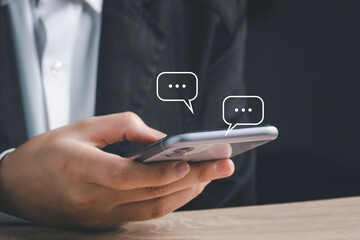 Live Chat on Communication social network Concept.  Hand using smartphone typing, chatting conversation in chat box icons pop up.