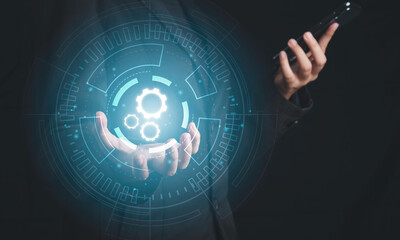 Digital workflow, Digital transformation, Automatic technology concept. Businessman holding digital machine gears  icons in cyber circle and holding smartphone.