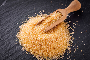 cane brown sugar on a dark stone background