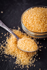 cane brown sugar on a dark stone background