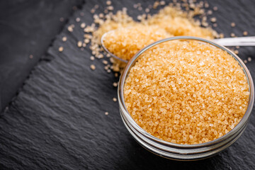 cane brown sugar on a dark stone background