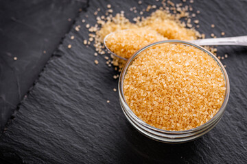 cane brown sugar on a dark stone background