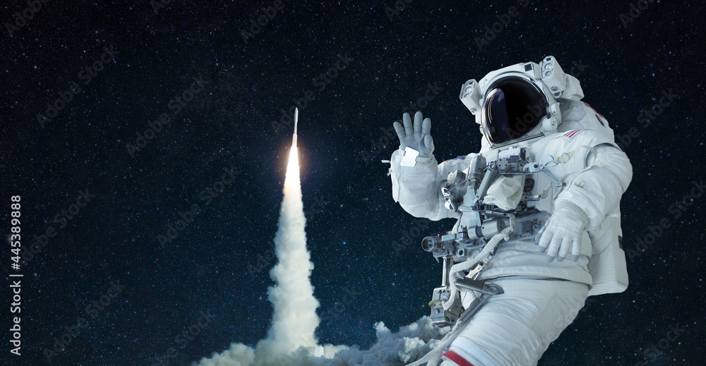 Poster space man in a space suit and hat travels in open space and waves his hand against the background of