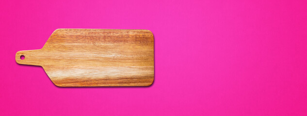 Wooden cutting board isolated on pink. Horizontal banner