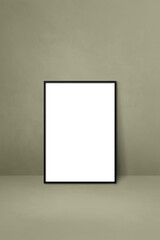Black picture frame leaning on a grey wall